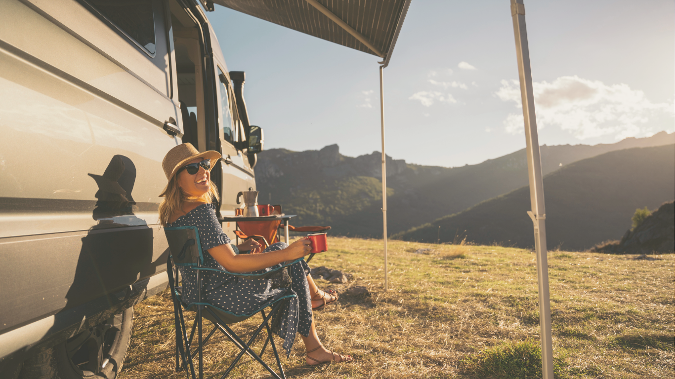 A woman gazing at mountain views from her RV, embodying the quiet freedom of off-grid RV camping.